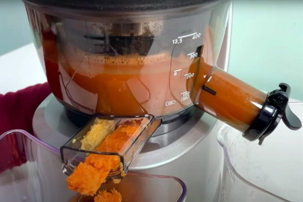 Juicing carrots in cold press juicer